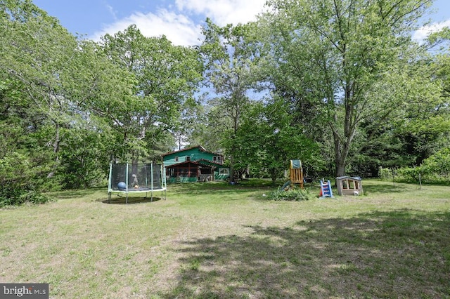 99 Old Main Shore Rd, Barnegat, NJ 08005 - view of grassy yard with a trampoline, a playground, and view of scattered trees