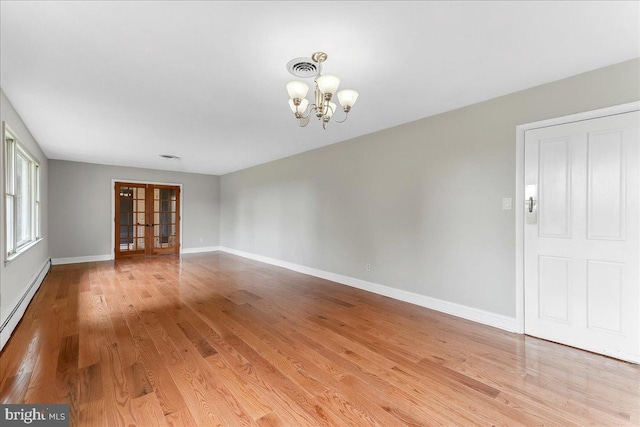 136 Schoolhouse Ln, Glen Mills, PA 19342 - empty room featuring a chandelier, a baseboard heating unit, light wood-type flooring, and french doors
