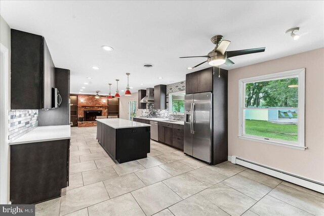 136 Schoolhouse Ln, Glen Mills, PA 19342 - kitchen featuring appliances with stainless steel finishes, wall chimney range hood, a baseboard radiator, light countertops, and backsplash