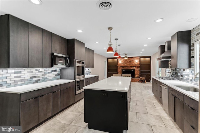 136 Schoolhouse Ln, Glen Mills, PA 19342 - kitchen with wall chimney exhaust hood, stainless steel appliances, a kitchen island, a fireplace, and backsplash