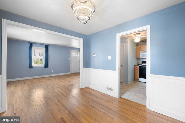 17 Alvil Rd, Wilmington, DE 19805 - empty room featuring wainscoting, a chandelier, and light wood-style flooring
