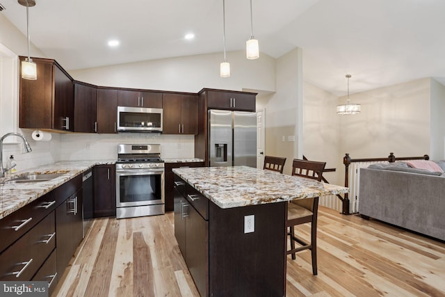 1442 Peacock Ln, Hellertown, PA 18055 - kitchen featuring appliances with stainless steel finishes, a breakfast bar area, lofted ceiling, light wood-style flooring, and tasteful backsplash