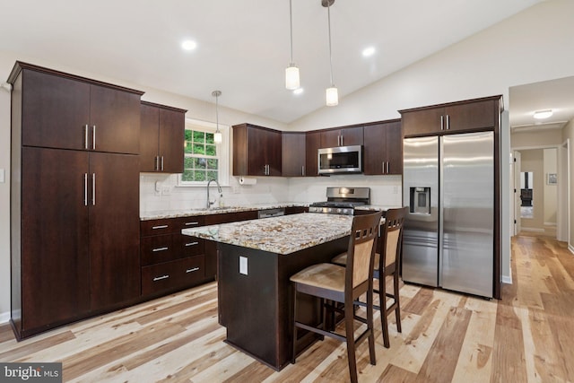 1442 Peacock Ln, Hellertown, PA 18055 - kitchen with stainless steel appliances, light wood-type flooring, dark brown cabinetry, backsplash, and lofted ceiling