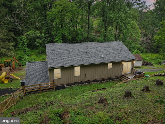 1442 Peacock Ln, Hellertown, PA 18055 - view of front facade with a shingled roof, a wooded view, and a playground