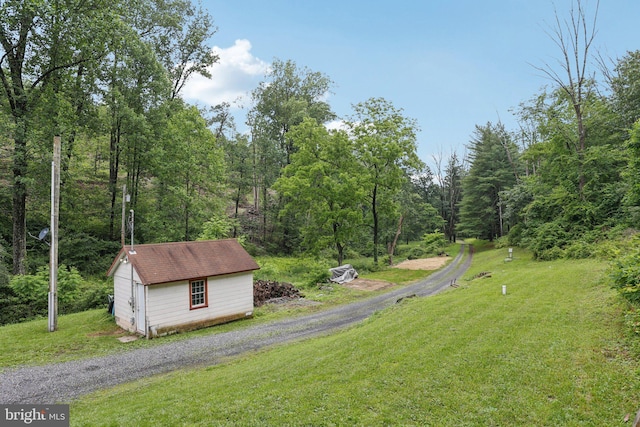 1442 Peacock Ln, Hellertown, PA 18055 - view of green lawn featuring a wooded view and a storage shed