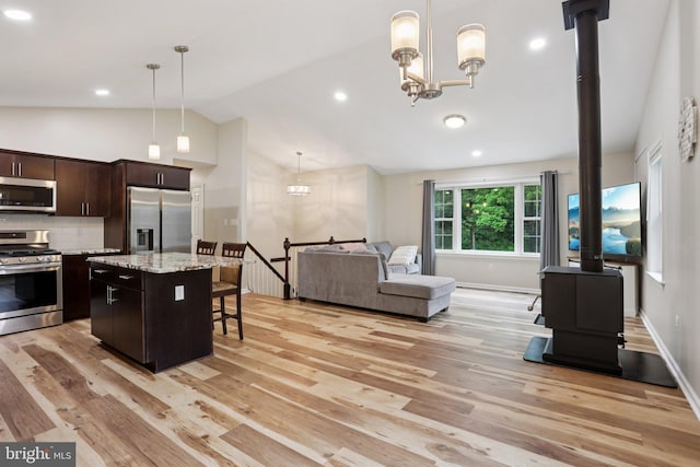 1442 Peacock Ln, Hellertown, PA 18055 - kitchen with stainless steel appliances, a kitchen breakfast bar, light wood-style flooring, open floor plan, and a wood stove