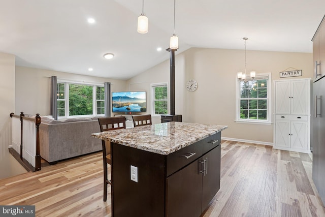 1442 Peacock Ln, Hellertown, PA 18055 - kitchen featuring a kitchen bar, light wood-style flooring, lofted ceiling, dark brown cabinets, and a center island