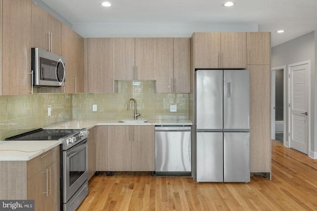 1640 Cambridge St, Philadelphia, PA 19130 - kitchen with appliances with stainless steel finishes, light brown cabinetry, light wood-type flooring, backsplash, and recessed lighting
