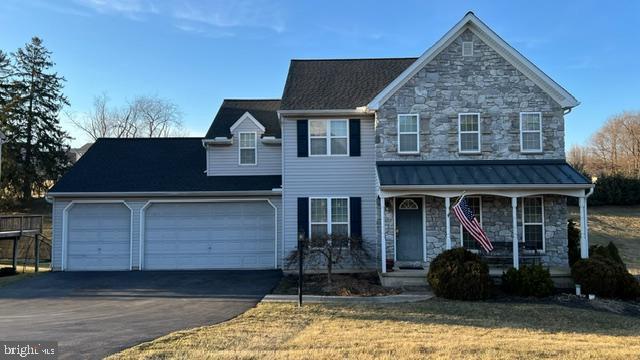 11 Parkview Dr, Seven Valleys, PA 17360 - traditional-style home with a porch, stone siding, asphalt driveway, a front yard, and an attached garage