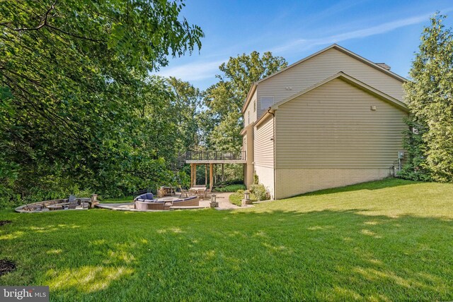 43858 Grantner Pl, Ashburn, VA 20147 - view of grassy yard with an outdoor fire pit, a patio area, and a deck