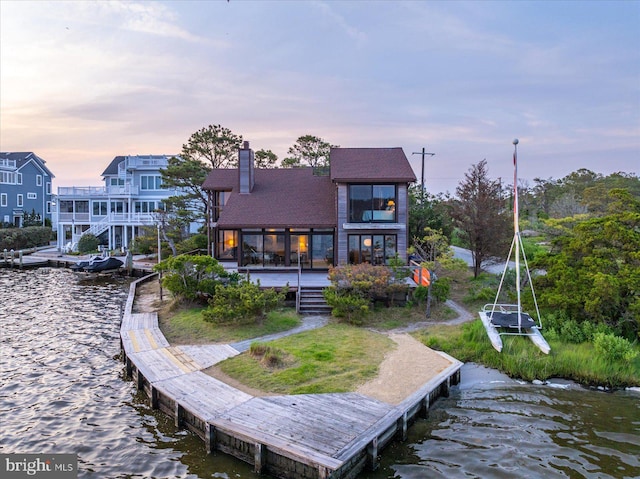 35197 Hassell Ave, Bethany Beach, DE 19930 - back of house at dusk with a chimney, roof with shingles, and a deck with water view