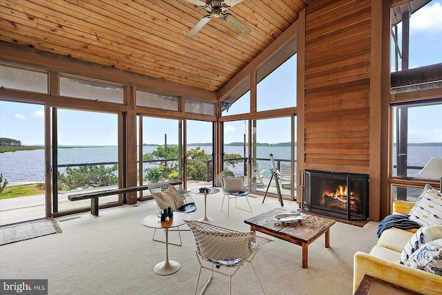 35197 Hassell Ave, Bethany Beach, DE 19930 - carpeted living area with a ceiling fan, a lit fireplace, a water view, high vaulted ceiling, and wood ceiling