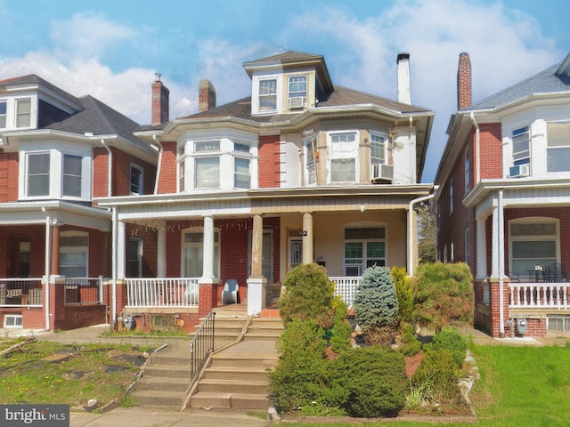 719 N 11th St, Allentown, PA 18102 - view of front of property featuring a porch, brick siding, and a chimney