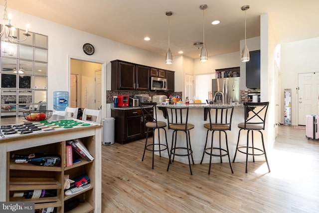 55 Hamlet Cir, Mechanicsburg, PA 17050 - kitchen with stainless steel appliances, dark brown cabinetry, light wood-type flooring, a kitchen breakfast bar, and recessed lighting