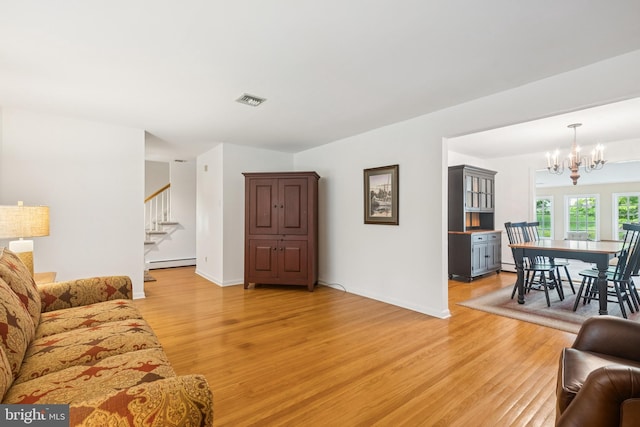 1243 Grove Rd, West Chester, PA 19380 - living area featuring baseboard heating, light wood-style flooring, stairway, and a chandelier