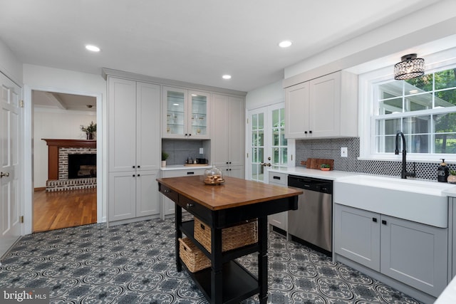 92 Lochatong Rd, Ewing, NJ 08628 - kitchen featuring stainless steel dishwasher, decorative backsplash, glass insert cabinets, plenty of natural light, and recessed lighting