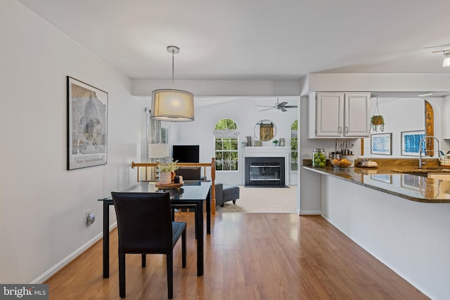 1908 Brigade Way, Odenton, MD 21113 - dining room with light wood-type flooring, ceiling fan, and a fireplace with flush hearth