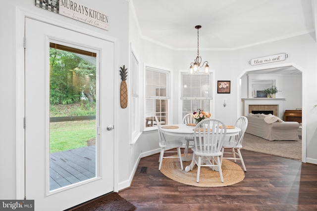11871 Knollcrest Ln, La Plata, MD 20646 - dining space featuring a chandelier, dark wood-style floors, ornamental molding, and a tile fireplace