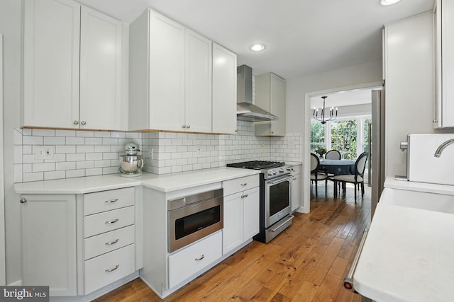 6134 Long Meadow Rd, Mclean, VA 22101 - kitchen featuring appliances with stainless steel finishes, wall chimney exhaust hood, light countertops, tasteful backsplash, and recessed lighting