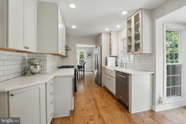 6134 Long Meadow Rd, Mclean, VA 22101 - kitchen with appliances with stainless steel finishes, light wood finished floors, glass insert cabinets, backsplash, and recessed lighting