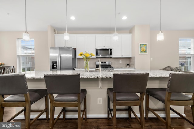 7802 Richard Halley Way, Elkridge, MD 21075 - kitchen with stainless steel appliances, tasteful backsplash, white cabinetry, a kitchen bar, and dark wood-style flooring