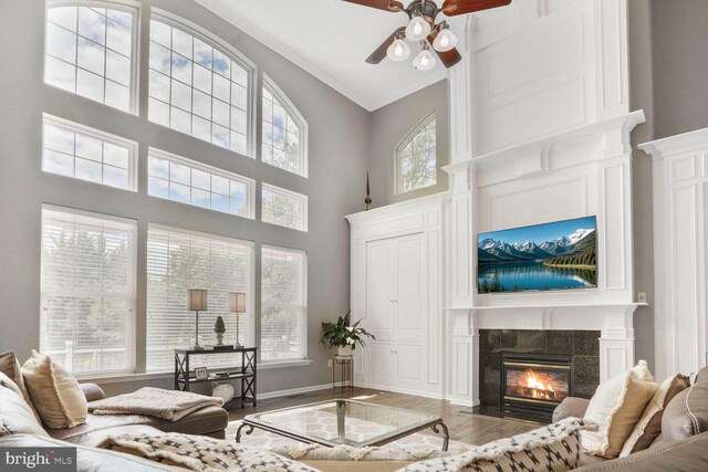 14401 Chalfont Dr, Haymarket, VA 20169 - living room featuring a ceiling fan, wood finished floors, a high end fireplace, a high ceiling, and crown molding
