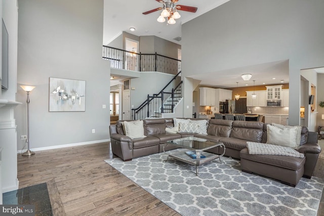 14401 Chalfont Dr, Haymarket, VA 20169 - living area with a high ceiling, wood finished floors, a ceiling fan, and stairs