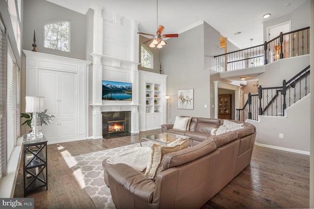 14401 Chalfont Dr, Haymarket, VA 20169 - living room with a towering ceiling, hardwood / wood-style floors, a tiled fireplace, ceiling fan, and stairway