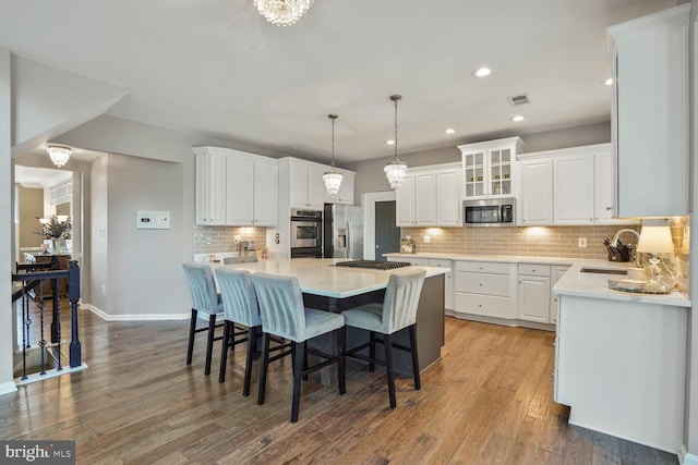 14401 Chalfont Dr, Haymarket, VA 20169 - kitchen with stainless steel appliances, white cabinetry, decorative backsplash, wood finished floors, and recessed lighting