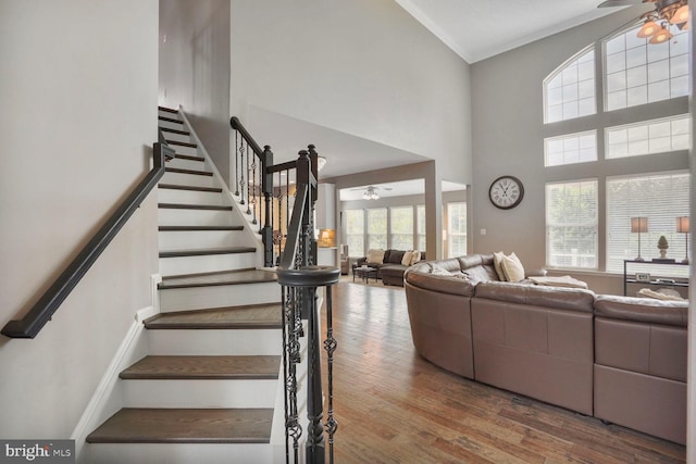 14401 Chalfont Dr, Haymarket, VA 20169 - living room with ceiling fan, stairs, wood finished floors, a towering ceiling, and ornamental molding
