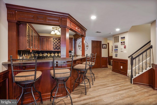 14401 Chalfont Dr, Haymarket, VA 20169 - indoor wet bar with stairway, light wood-style floors, decorative backsplash, recessed lighting, and a wainscoted wall