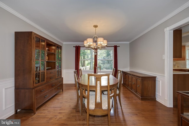561 Nottingham Dr, Yardley, PA 19067 - dining space with wainscoting, a chandelier, a decorative wall, wood finished floors, and crown molding