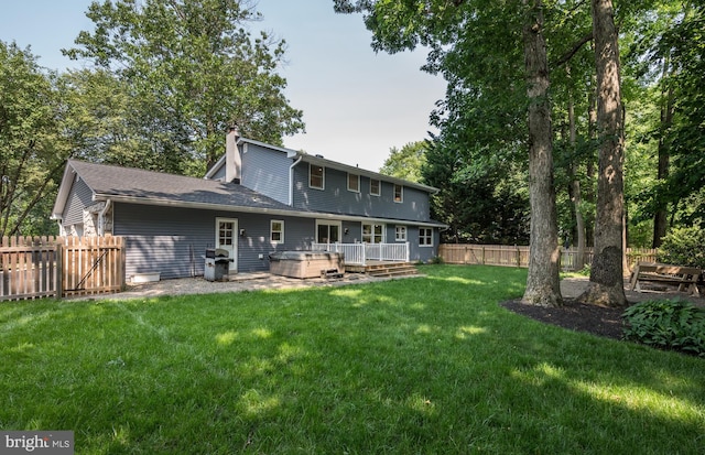 561 Nottingham Dr, Yardley, PA 19067 - back of property featuring a fenced backyard, a chimney, a hot tub, and a wooden deck