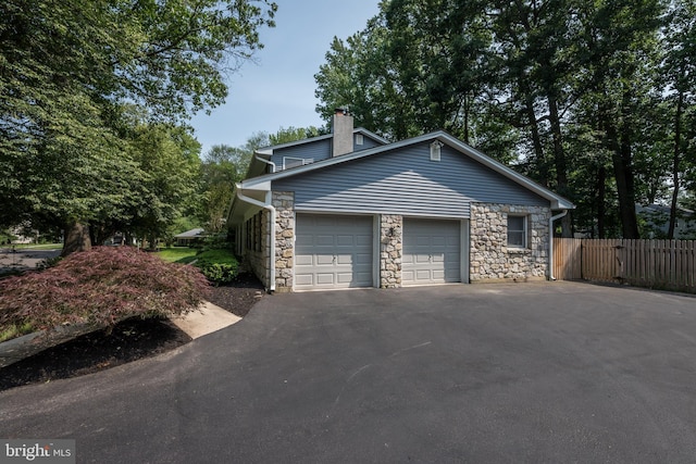 561 Nottingham Dr, Yardley, PA 19067 - view of property exterior with stone siding, driveway, an attached garage, and a chimney