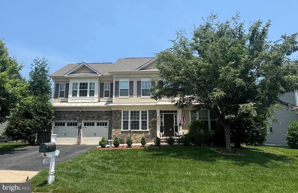 6560 Wellspring Ct, Warrenton, VA 20187 - view of front of property featuring driveway, an attached garage, a front lawn, stone siding, and a standing seam roof