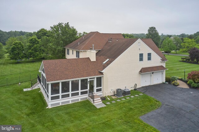 21 Shara Ln, Pennington, NJ 08534 - back of property with a sunroom, a garage, roof with shingles, asphalt driveway, and stucco siding