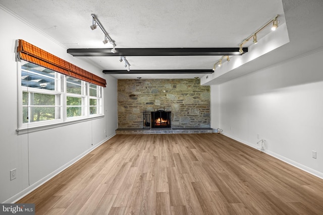 951 Robin Ln, Huntingdon Valley, PA 19006 - unfurnished living room with rail lighting, wood finished floors, a fireplace, and a textured ceiling
