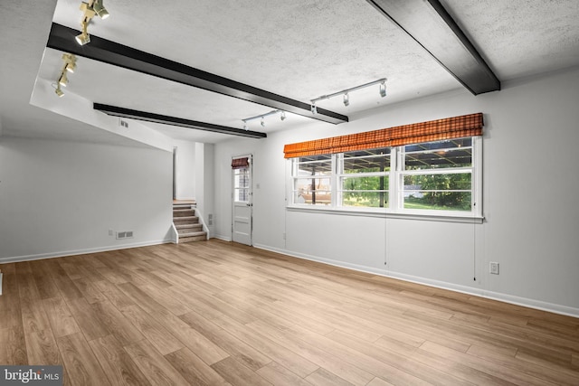 951 Robin Ln, Huntingdon Valley, PA 19006 - unfurnished living room with track lighting, wood finished floors, a textured ceiling, stairs, and beam ceiling