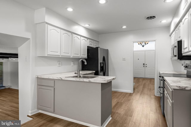 951 Robin Ln, Huntingdon Valley, PA 19006 - kitchen with stainless steel appliances, light wood-type flooring, white cabinetry, a peninsula, and recessed lighting