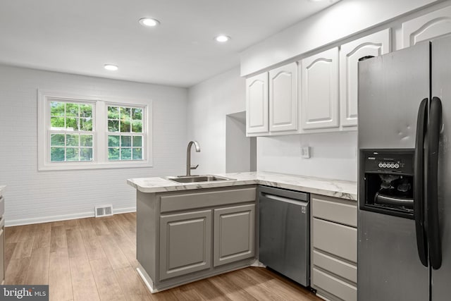 951 Robin Ln, Huntingdon Valley, PA 19006 - kitchen featuring appliances with stainless steel finishes, a peninsula, white cabinets, light stone counters, and gray cabinetry