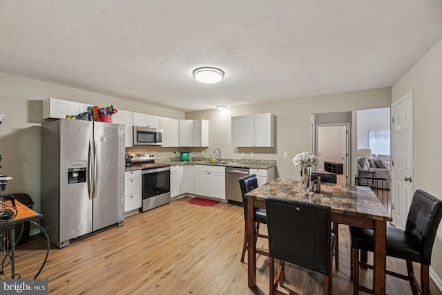 41 Sycamore Ln, Hanover, PA 17331 - kitchen with appliances with stainless steel finishes, light wood-style flooring, white cabinets, and a textured ceiling