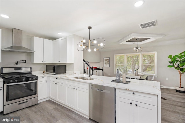 1427 Perrywood Dr, Aberdeen, MD 21001 - kitchen featuring stainless steel appliances, wall chimney range hood, a peninsula, light wood-type flooring, and recessed lighting