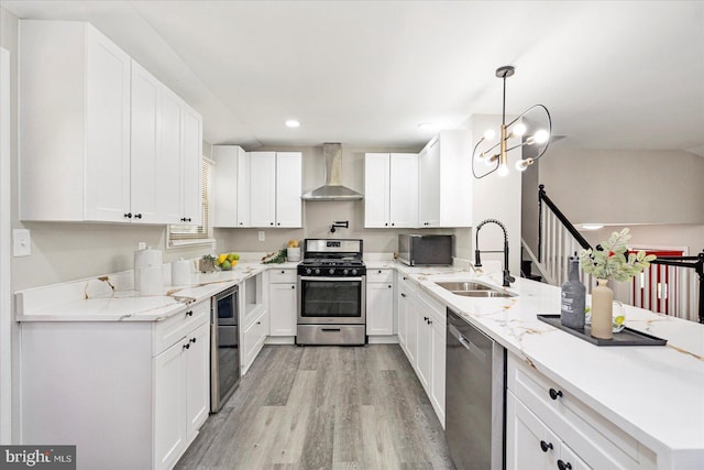 1427 Perrywood Dr, Aberdeen, MD 21001 - kitchen with stainless steel appliances, wall chimney exhaust hood, a peninsula, light wood-type flooring, and white cabinetry