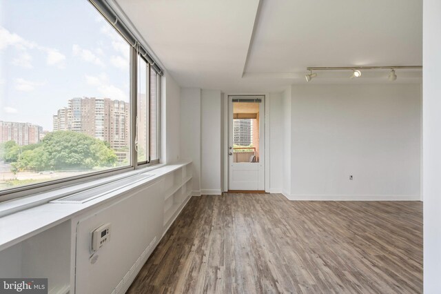 1111 Arlington Blvd Unit 707, Arlington, VA 22209 - empty room featuring wood finished floors, healthy amount of natural light, a city view, and track lighting