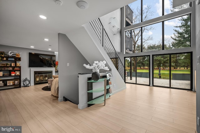 110 Rue Du Boise, Cherry Hill, NJ 08003 - living area featuring stairs, wood finished floors, a glass covered fireplace, recessed lighting, and a high ceiling