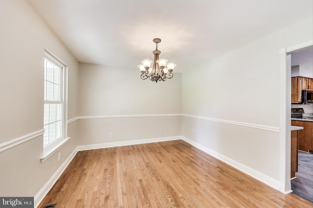 6260 Alpine Ct, Sunderland, MD 20689 - empty room featuring light wood-style flooring, plenty of natural light, and a chandelier