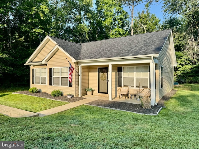 253 American Dr, Ruther Glen, VA 22546 - view of front facade featuring a front yard, a shingled roof, and covered porch