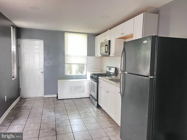 2238 N Bancroft St, Philadelphia, PA 19132 - kitchen featuring stainless steel appliances, white cabinetry, light tile patterned floors, backsplash, and light countertops