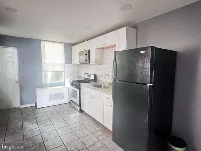 2238 N Bancroft St, Philadelphia, PA 19132 - kitchen featuring freestanding refrigerator, gas stove, white cabinetry, and light tile patterned floors