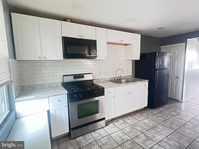 2238 N Bancroft St, Philadelphia, PA 19132 - kitchen with black appliances, tasteful backsplash, white cabinetry, and light tile patterned floors